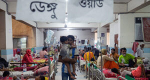 বরগুনায় নার্সদের ডেস্কের পিছনে মেঝেতে ডেঙ্গু রোগীদের চিকিৎসা দেওয়া হচ্ছে